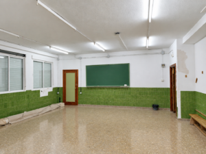 Aula vacía con pizarra verde y ventanales