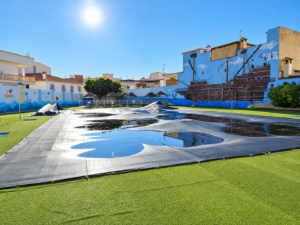 Patio mediterráneo con piscina cubierta y murales veraniegos